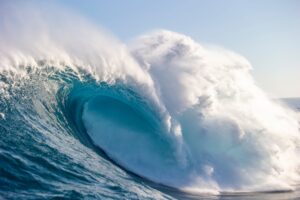 A vibrant print of a large ocean wave with a blue and white color palette, representing the product '20FT+ Jaws'.
