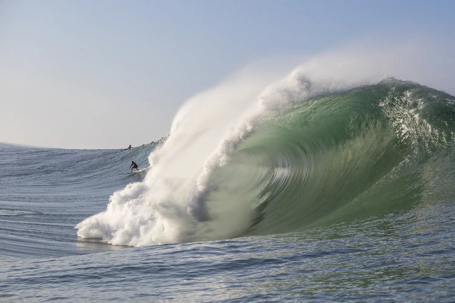 Trevor Carlson charging a deep emerald Mavericks wall, professional big wave photography.