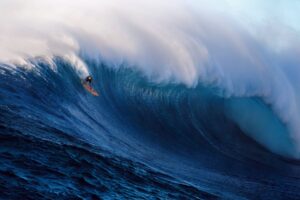 Person surfing a large wave in the ocean