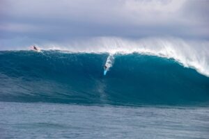 Jaws turquoise wave breaking curling above surfer in a epic day
