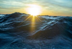 Sunrise over rough ocean waves