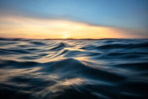 Sunset over the ocean with wavy water