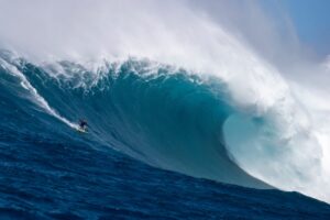 Person surfing a large wave in the ocean
