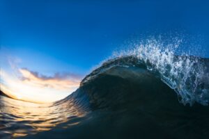 Wave breaking with a sunset in the background