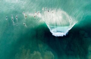 Surfers riding a large wave in the ocean