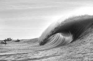 Boats and surfers in black and white professional photography epic big 
wave 