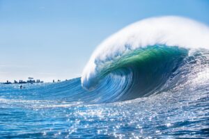 surfers a big large wave spot curling over all with withe foam