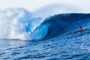 Person on a surfboard riding a large wave in the ocean