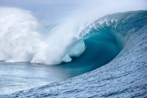 Large big ocean wave Mavericks, Jaws. photo with white foam curling over itself against a blue sky