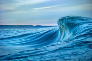 Large wave in the ocean with a clear sky